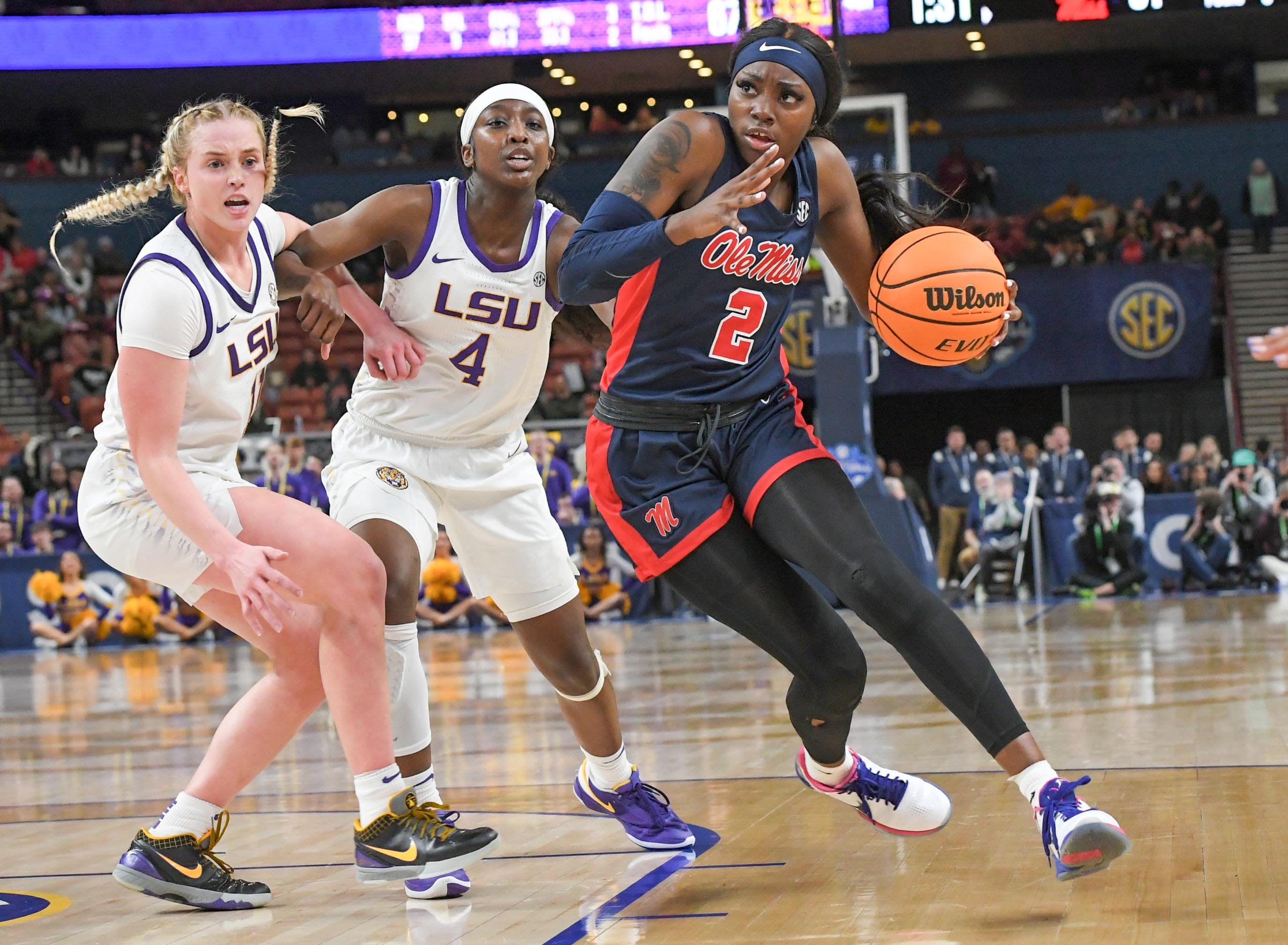 Ole Miss guard Marquesha Davis (2) drives by Louisiana State University guard Flau'jae Johnson (4) and Hailey Van Lith (11) during the fourth quarter of the SEC Women's Basketball Tournament game at the Bon Secours Wellness Arena in Greenville, S.C. Saturday, March 9, 2024.