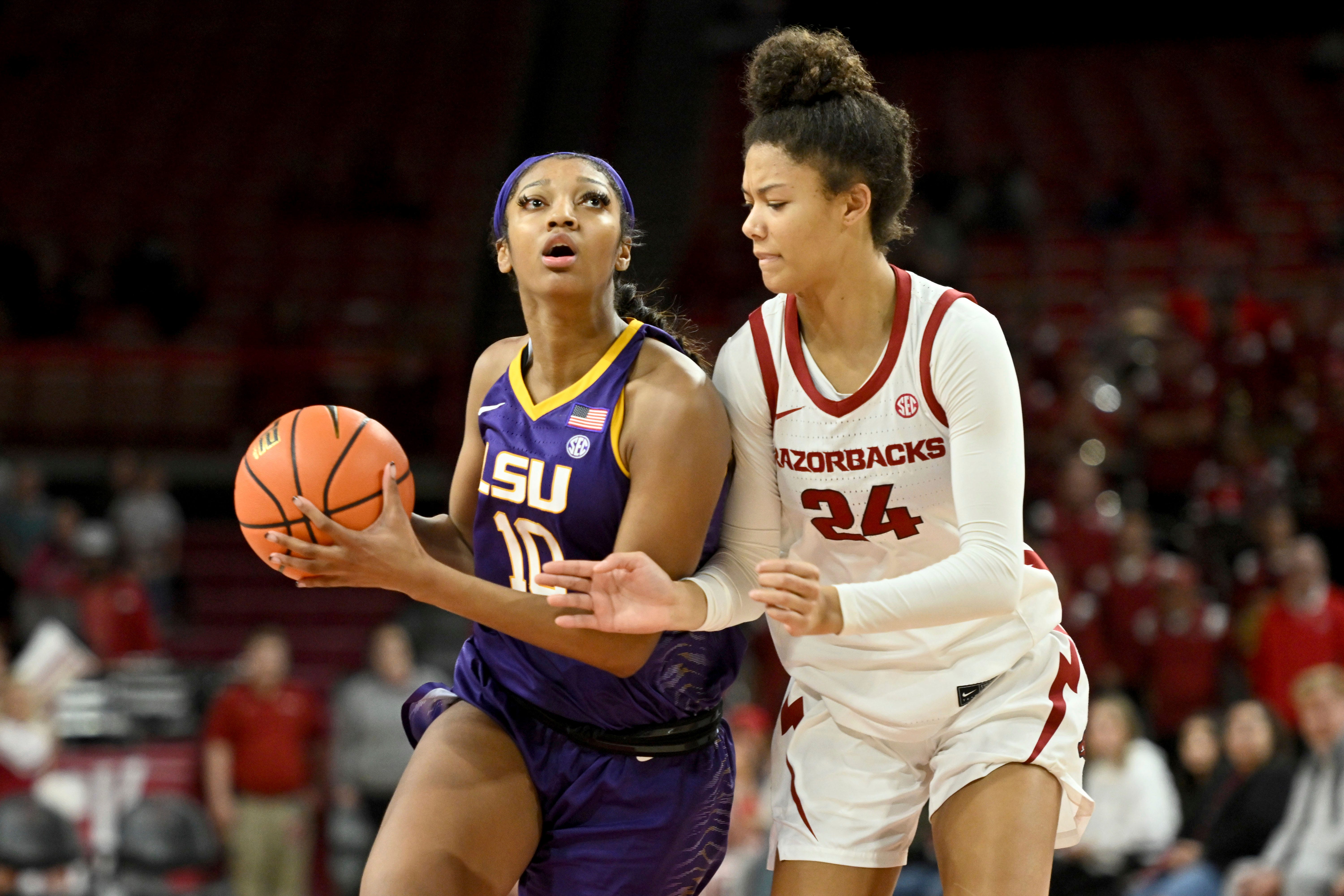 LSU forward Angel Reese (10) tries to drive past Arkansas guard Jersey Wolfenbarger (24) during an NCAA basketball game on Thursday, Dec. 29, 2022, in Fayetteville, Ark. (AP Photo/Michael Woods)