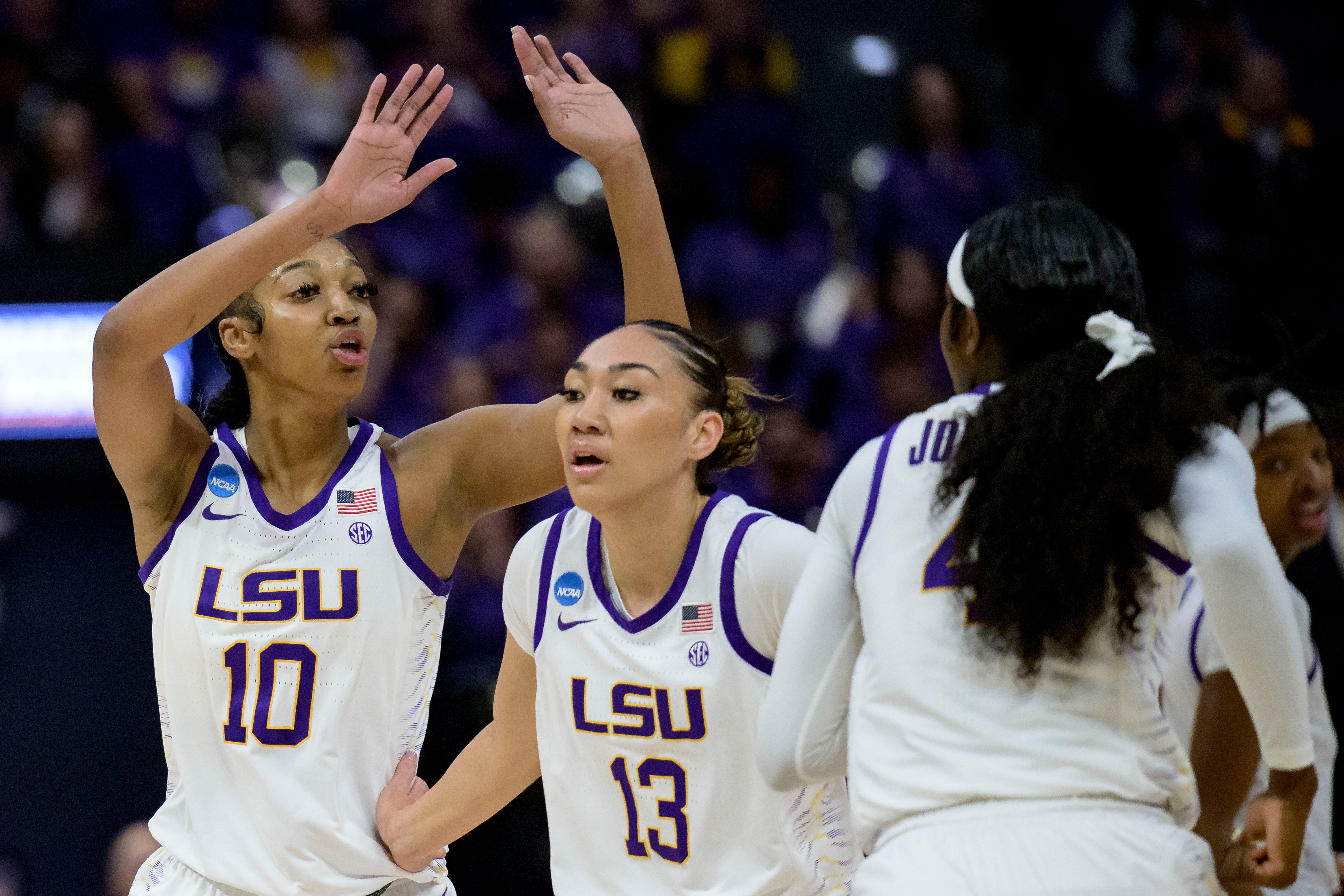 LSU forward Angel Reese (10) celebrates with guard Last-Tear Poa (13) and guard Flau'jae Johnson, right, during the first half of the team's first-round college basketball game against Hawaii in the women's NCAA Tournament in Baton Rouge, La., Friday, March 17, 2023. (AP Photo/Matthew Hinton)