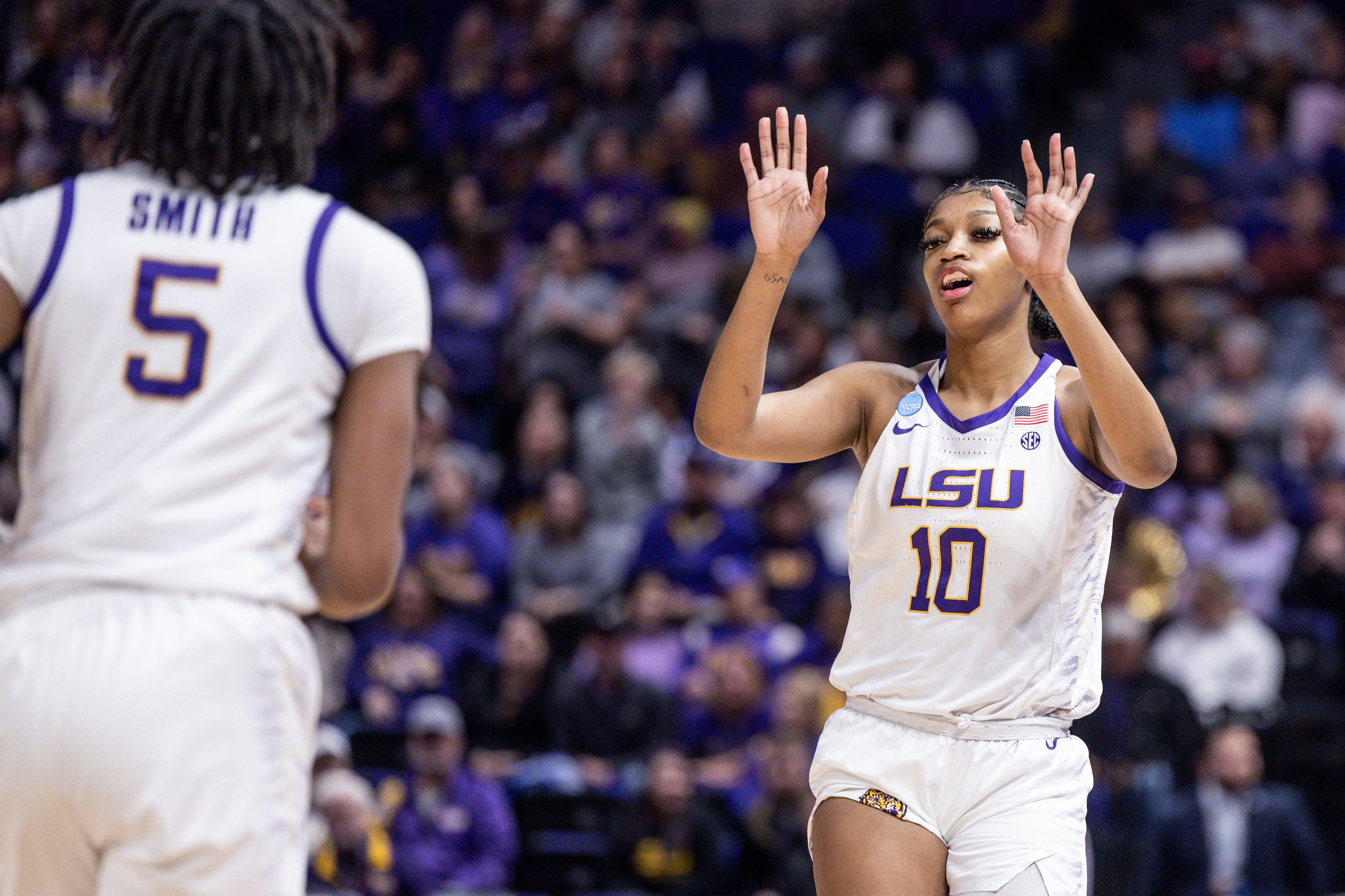 LSU Tigers forward Angel Reese (10) tags forward Sa'Myah Smith (5) against the Michigan Wolverines during the first half at Pete Maravich Assembly Center in Baton Rouge, Louisiana, on Sunday, March 19, 2023.