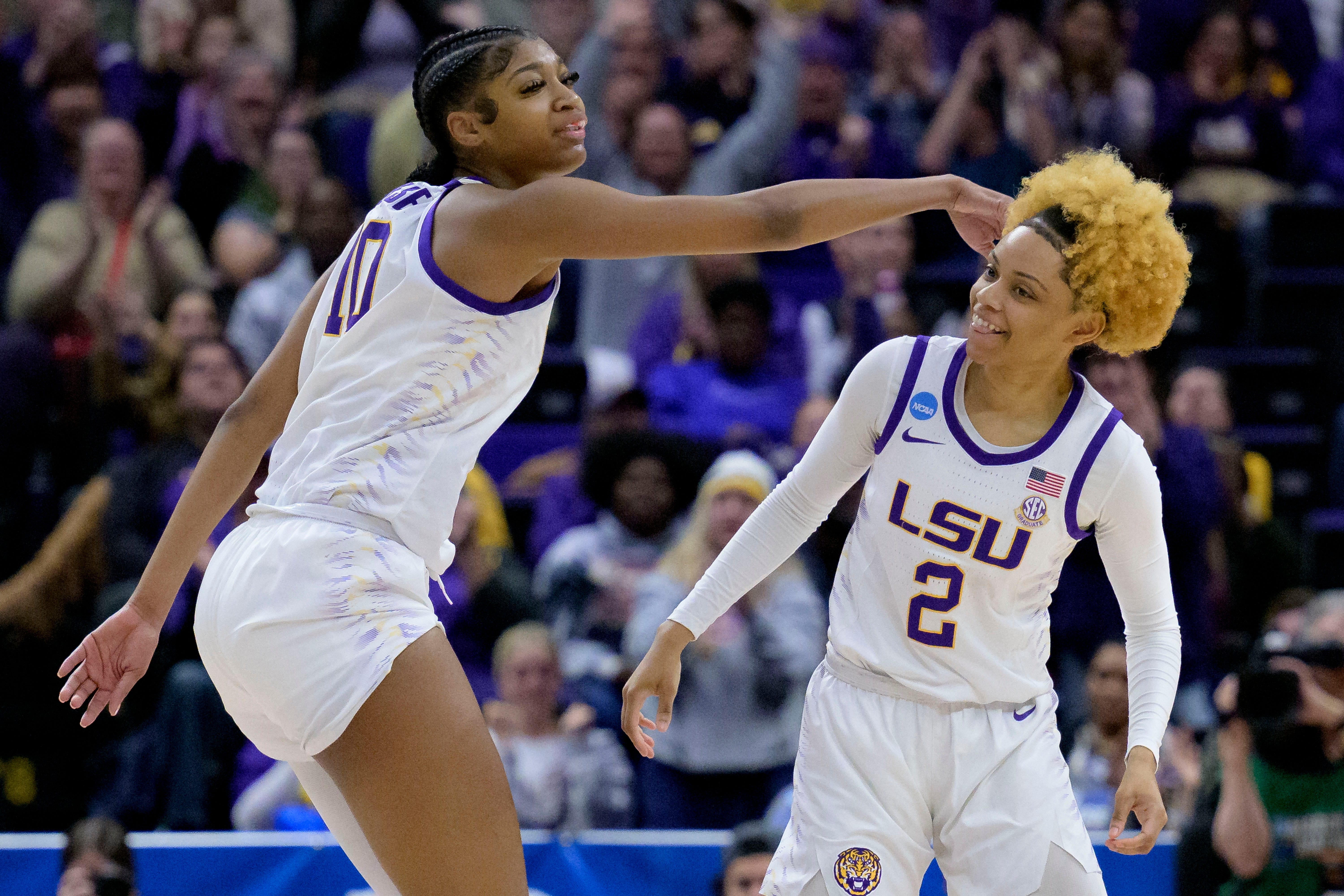 LSU forward Angel Reese (10) celebrates the 3-point basket of guard Jasmine Carson (2) during the first half of the team's second-round college basketball game against Michigan in the women's NCAA Tournament in Baton Rouge, La., Sunday, March 19, 2023. (AP Photo/Matthew Hinton)