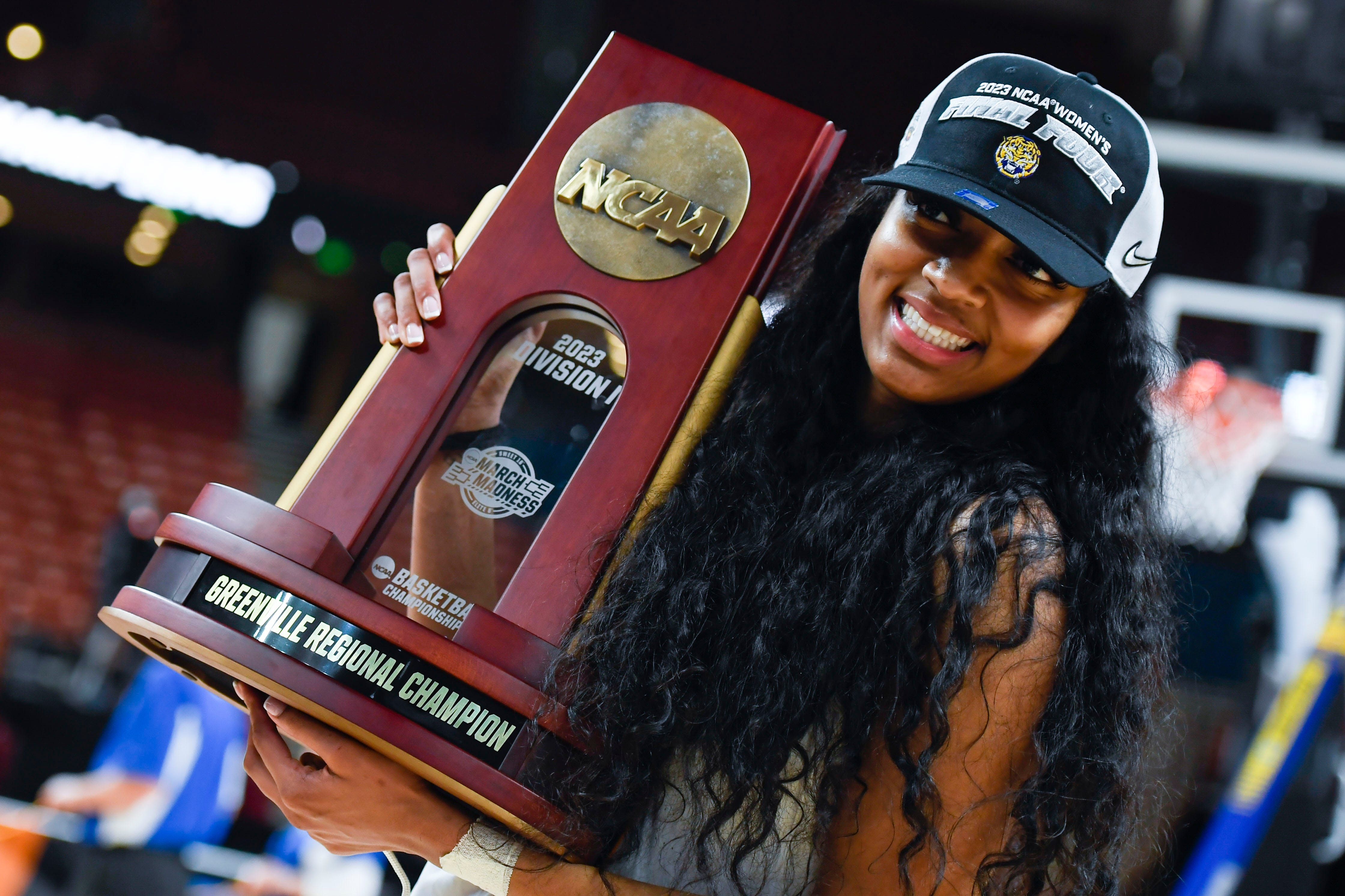 Louisiana State University forward Angel Reese (10) holds the NCAA trophy after winning the NCAA Women's Greenville Regional Elite Eight Basketball Tournament at Bon Secours Wellness Arena in Greenville, S.C. Sunday, March 26, 2023.