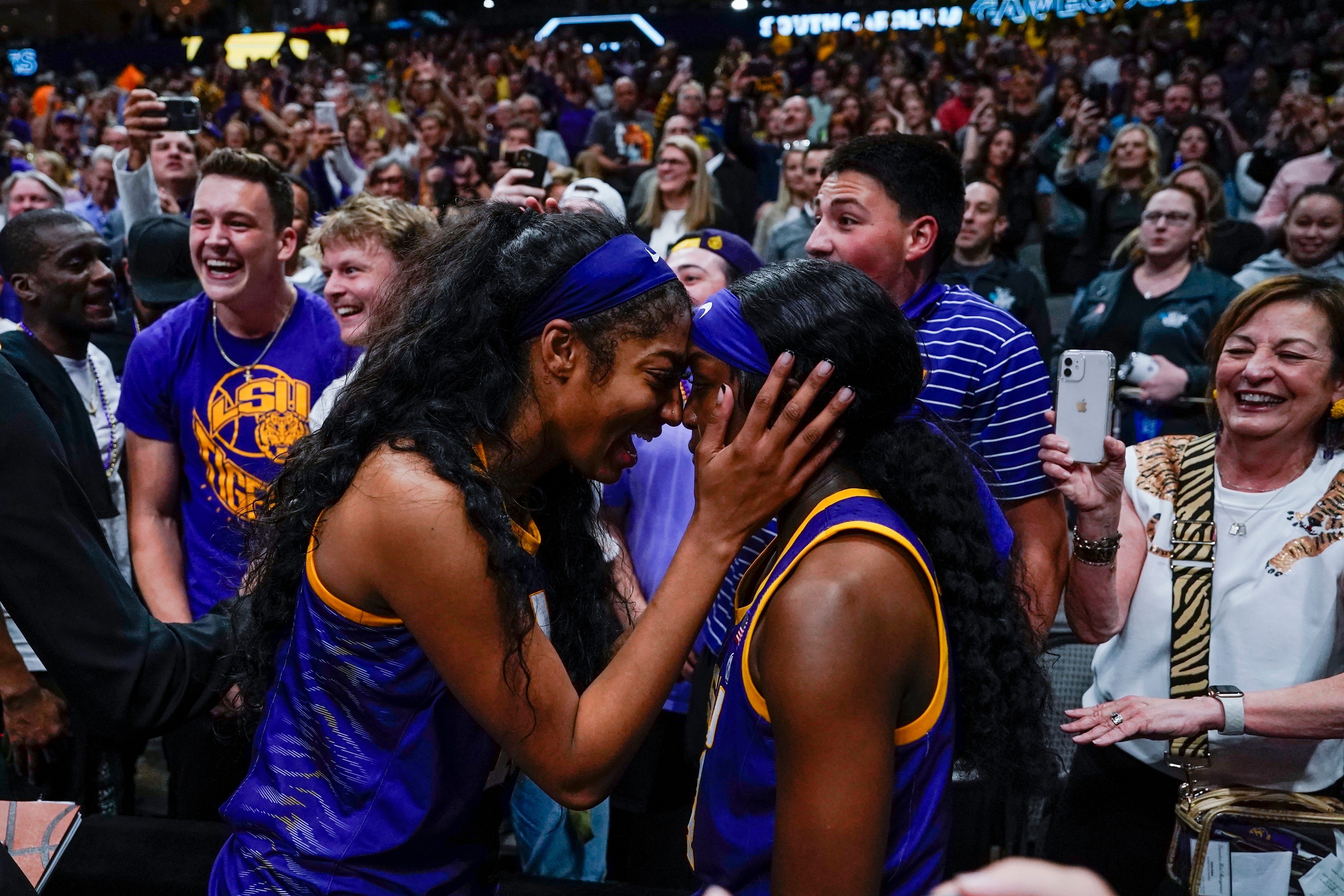 LSU's Flau'jae Johnson and Angel Reese celebrate in the crowd after an NCAA Women's Final Four semifinals basketball game against Virginia Tech Friday, March 31, 2023, in Dallas. LSU won 79-72 to advance to the championship game on Sunday. (AP Photo/Darron Cummings)